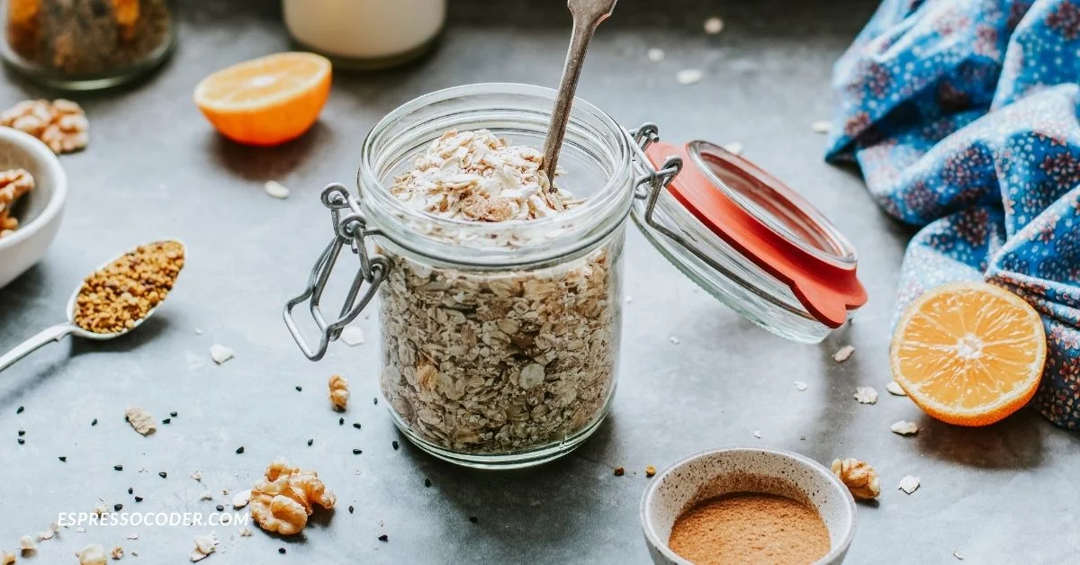 Insoya protein powder in glass jar with wooden spoon on table.