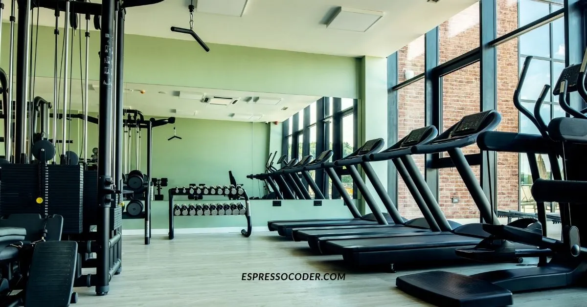Modern gym lumolog equipment with treadmills, weights, and strength machines.